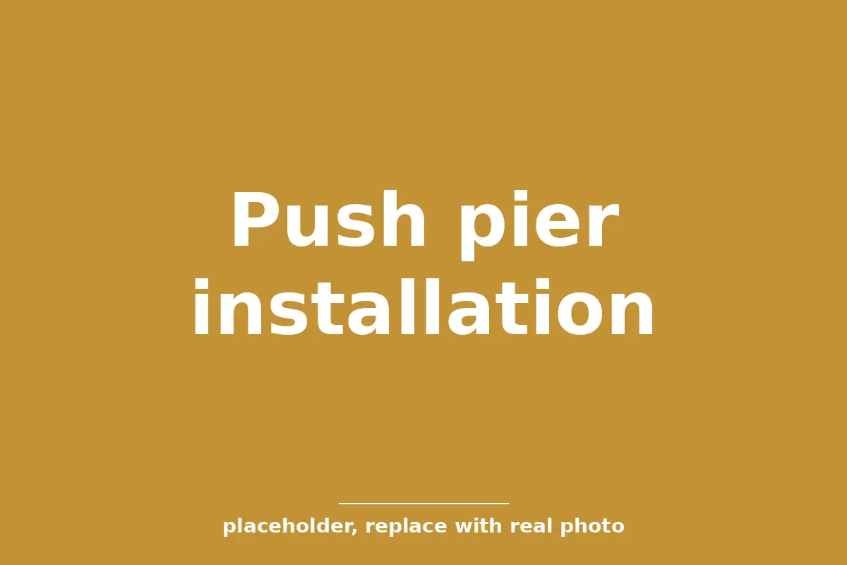 Push pier bracket and steel pipe installed under the footing of a brick home in Tulsa