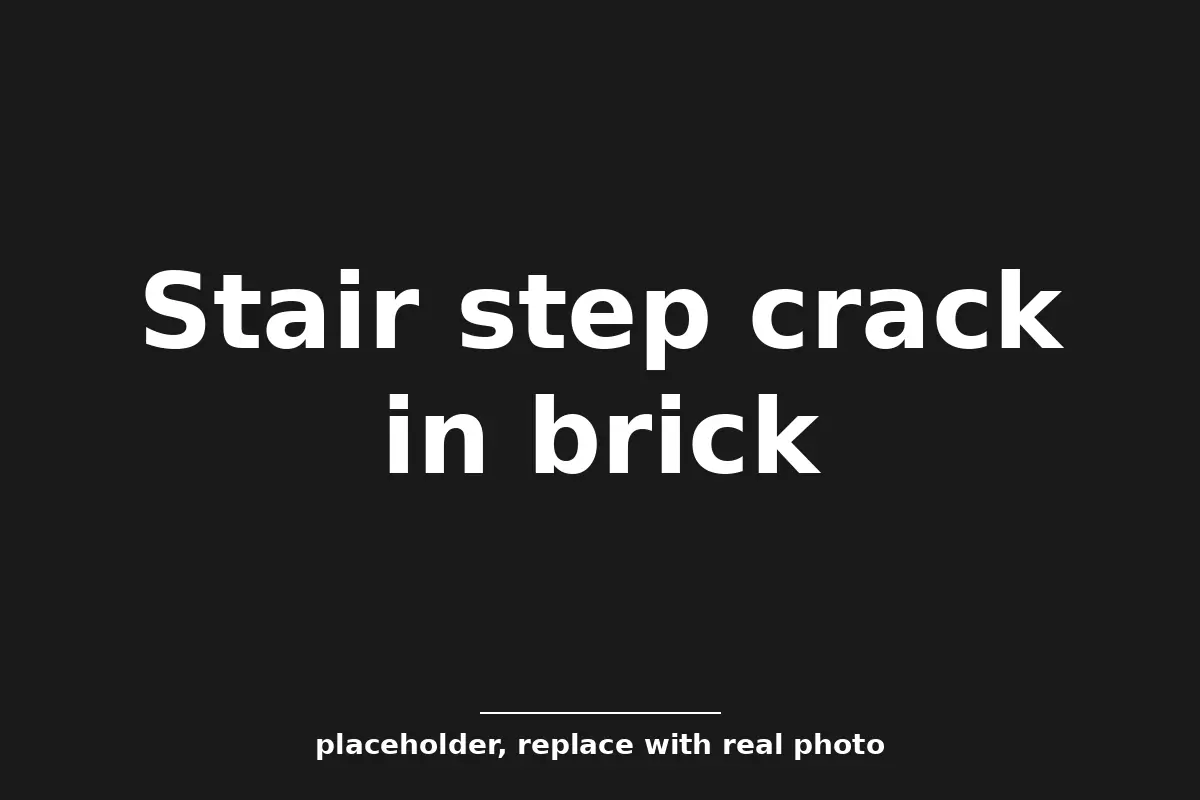 Stair step crack running through brick mortar joints on a Tulsa home, a common sign of foundation settlement